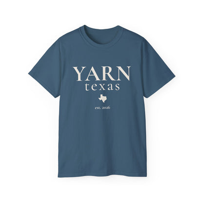 A blue short-sleeve crewneck t-shirt with 'YARN texas est. 2026' printed in black on the front, displayed against a solid white background.
