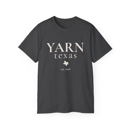 A dark heathered gray short-sleeve crewneck t-shirt with 'YARN texas est. 2026' printed in black on the front, displayed against a solid white background.