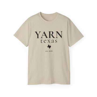 A beige short-sleeve crewneck t-shirt with a black graphic print reading 'YARN texas est. 2026' and a Texas state silhouette, displayed on a clean white background.